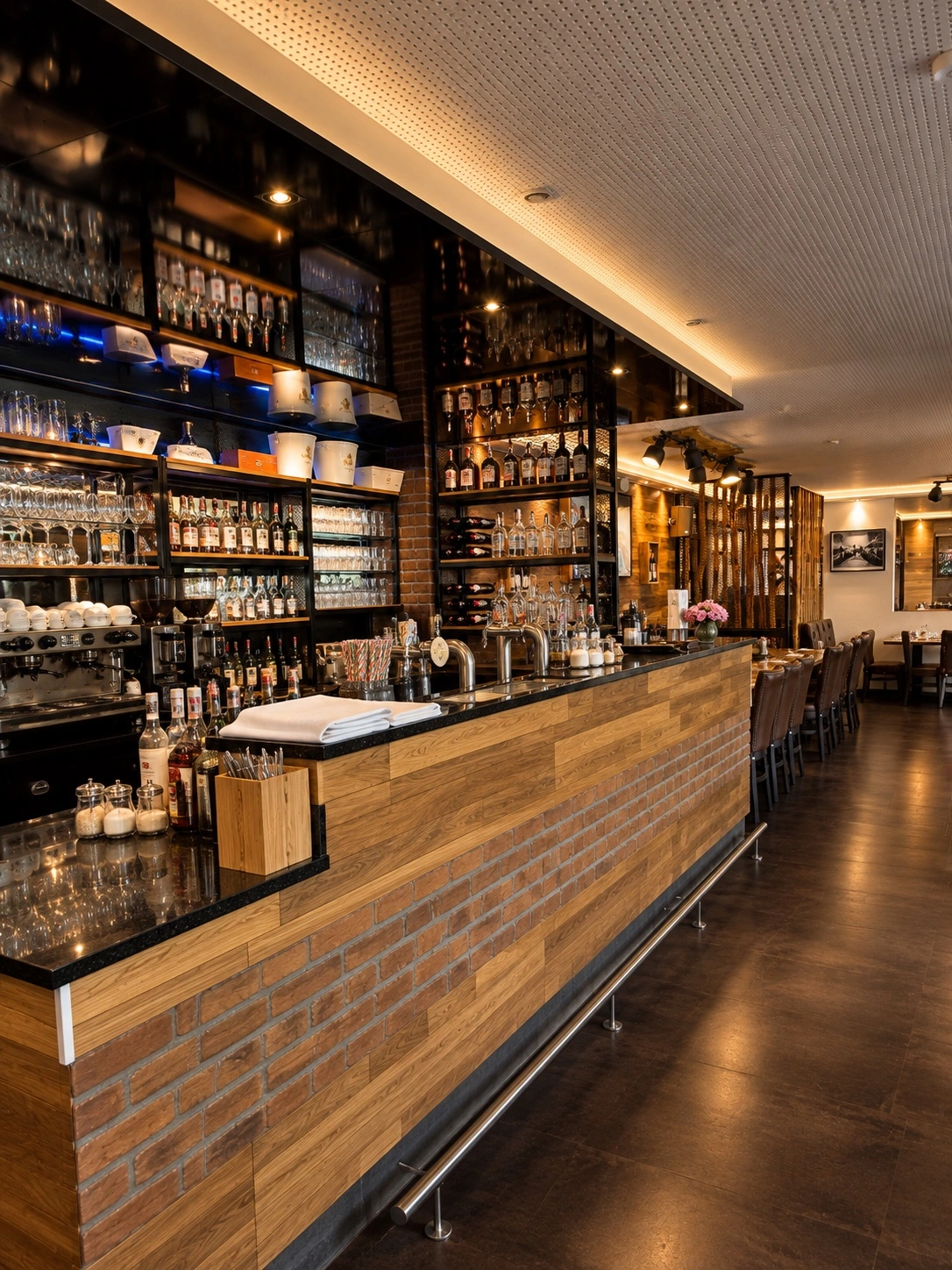 Die Acanto-Bar mit Holztheke und beleuchteten Regalen